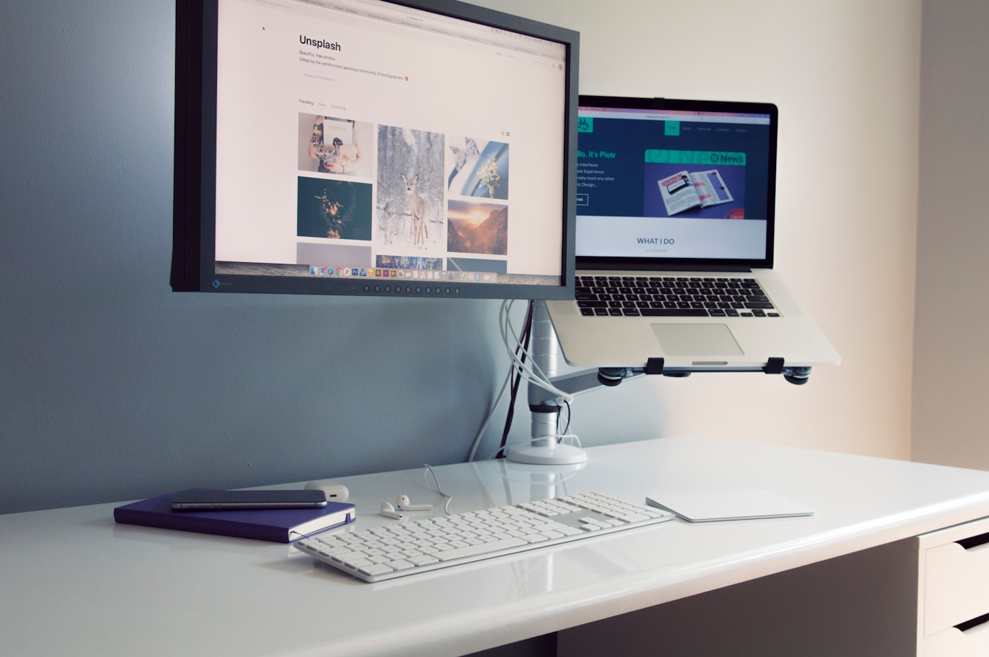 An organized desk with dual monitors and a laptop stand.