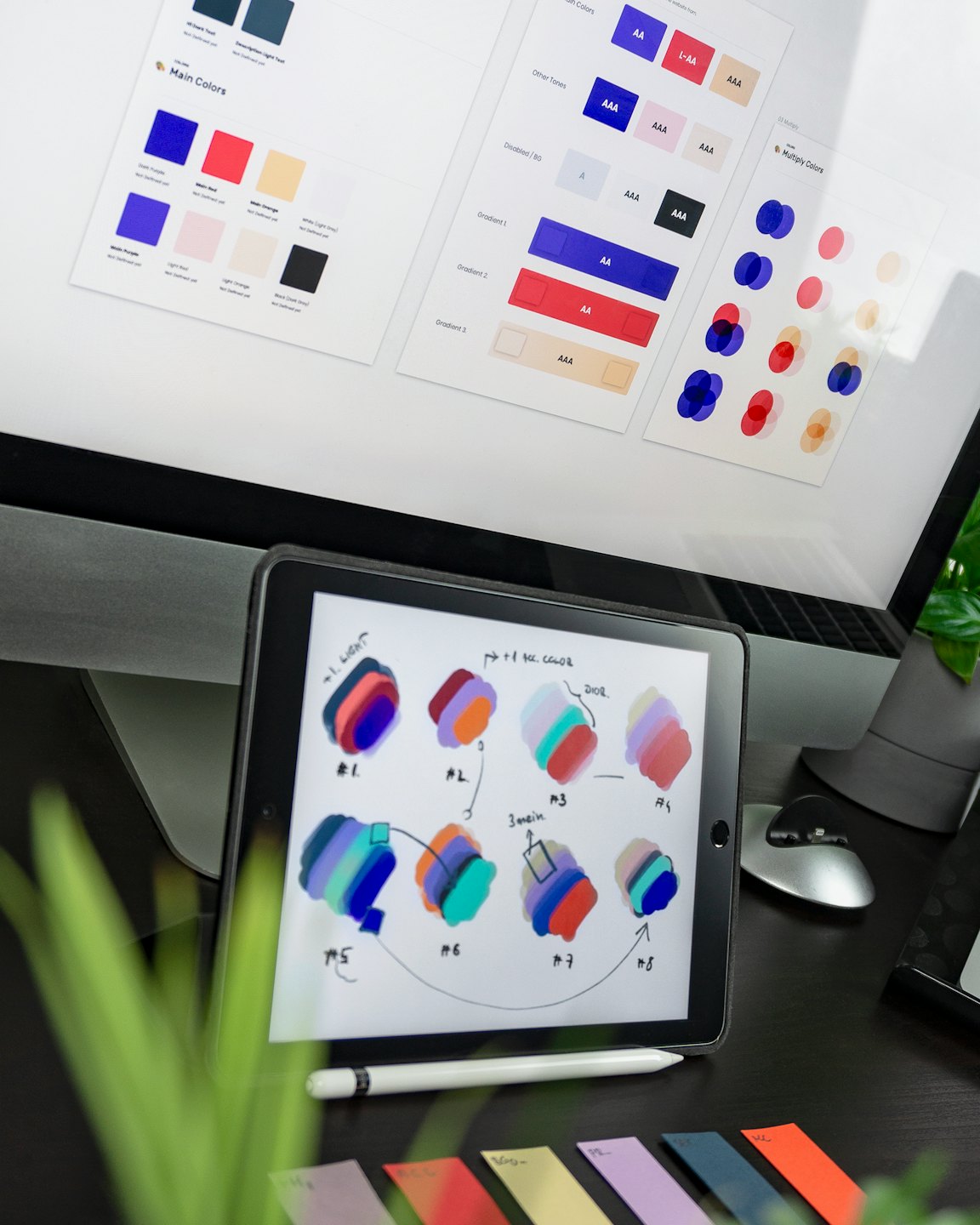 Computer monitor and tablet showing design work and color swatches.